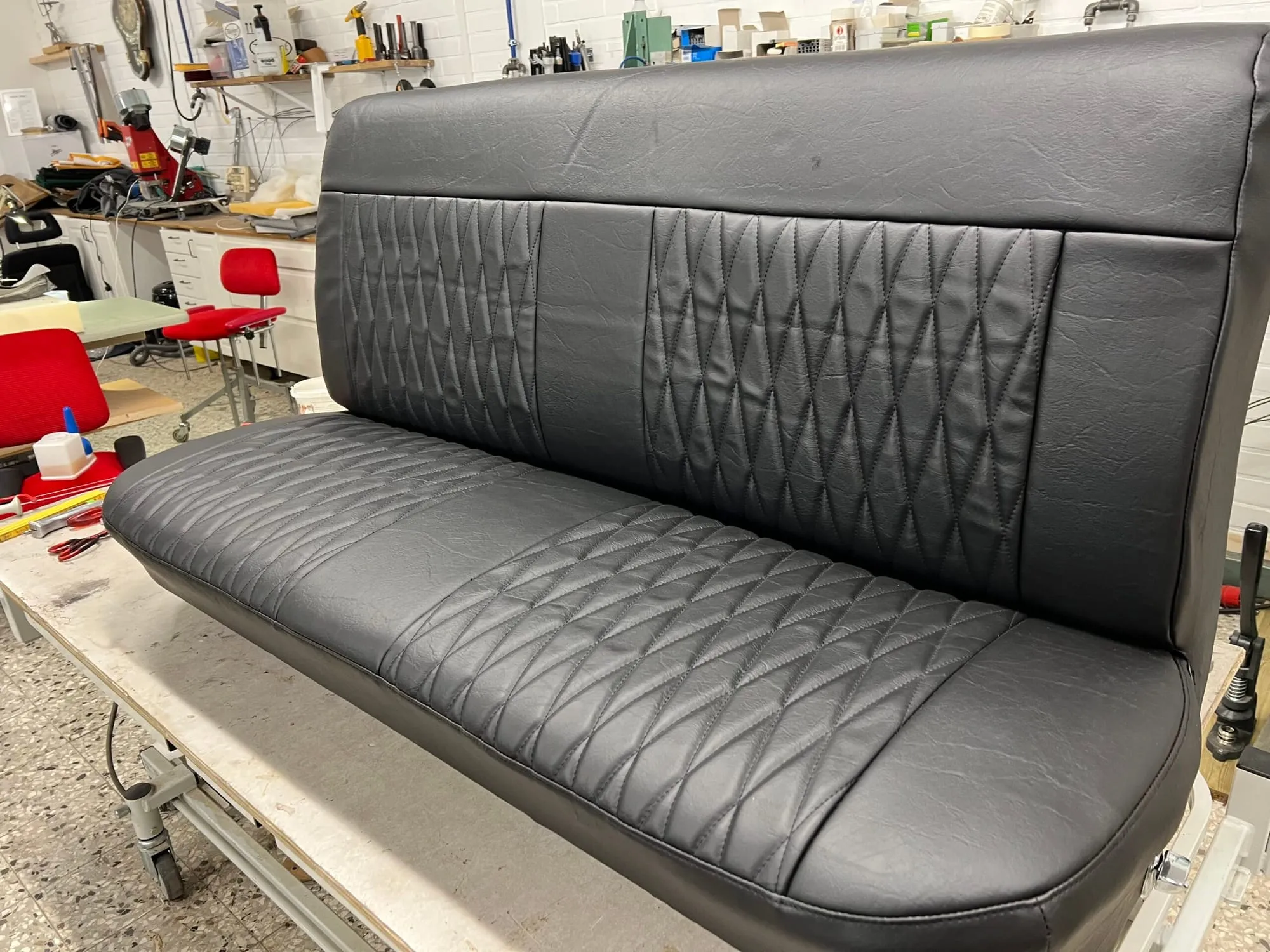 Svart bilbänk med quiltade fält på arbetsbänken